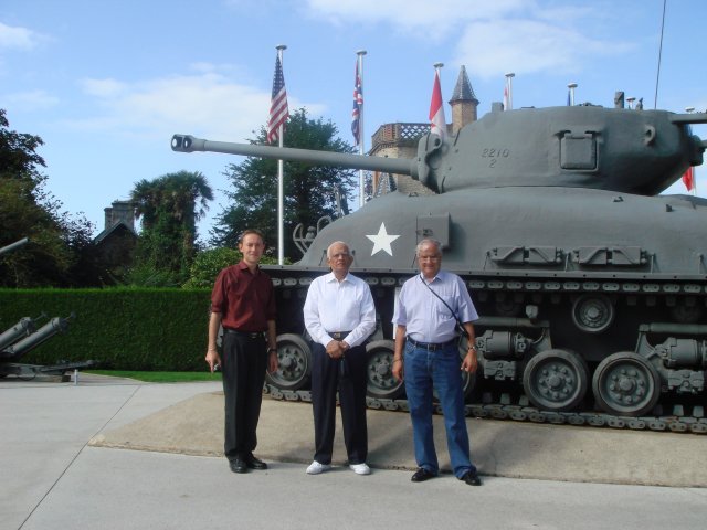 Christophe with travelers in front of an army tank in Normandy