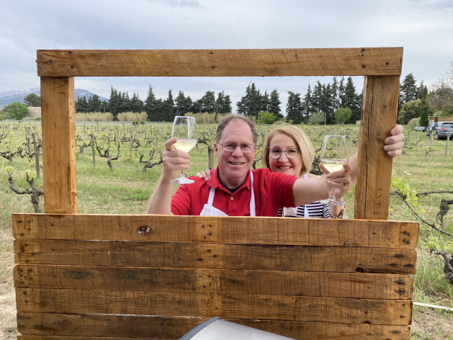 Travelers Diana and Michael pictured in Chef Benoit's vineyard, enjoying a glass of wine