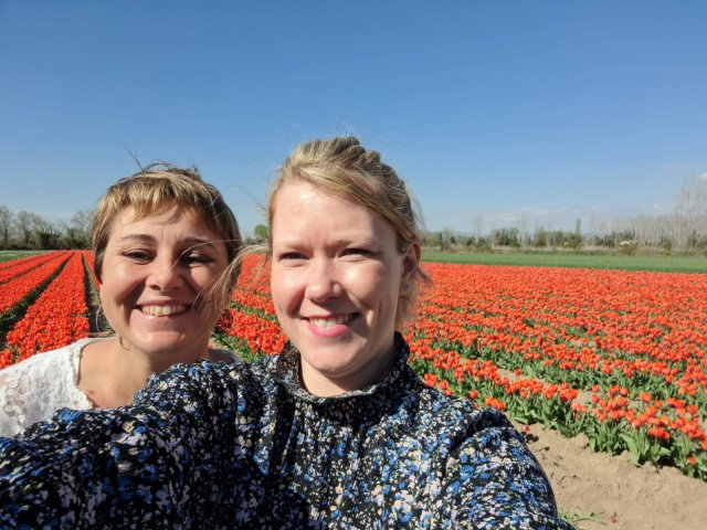 Trip planners Emilie and Clelia in front of a field of red tulips in Provence