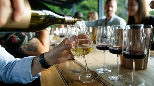 White wine being poured into a glass at a wine-tasting